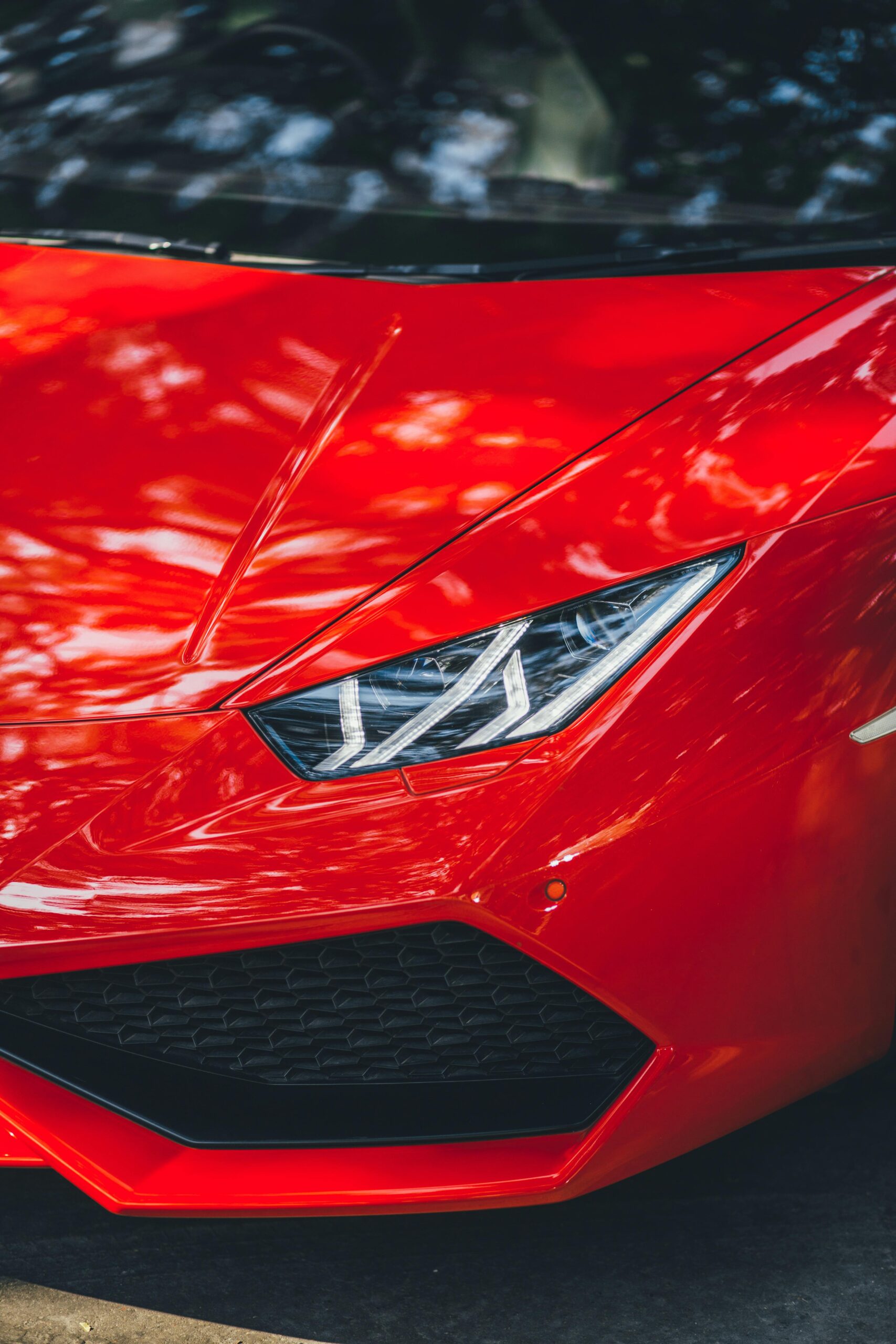 Close-up of a red Lamborghini Huracan parked on a street in New Delhi, India.
